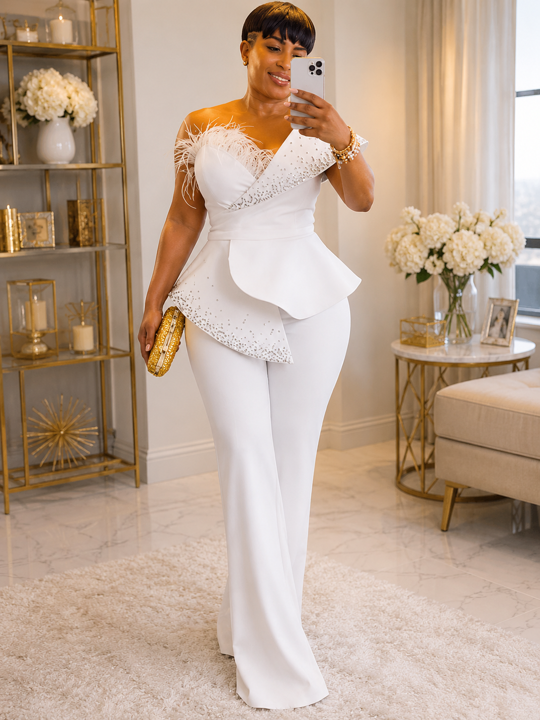 Woman in a white one-shoulder dress taking a selfie in a stylish room.