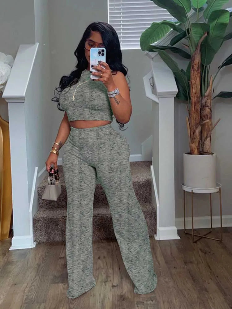 Woman taking a mirror selfie wearing a green outfit in a home setting.