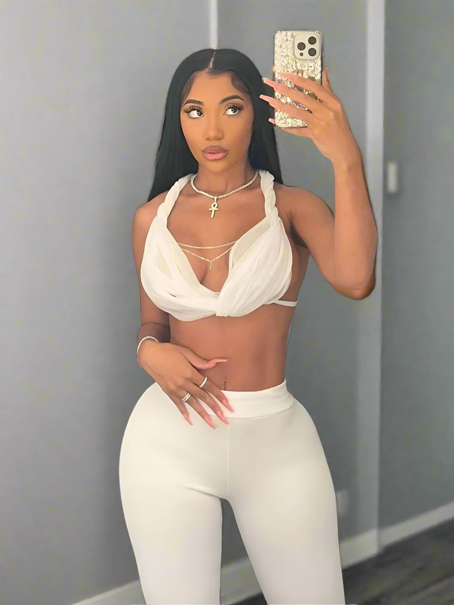 ng.Woman taking a mirror selfie wearing a white outfit with 'kliou' brandi