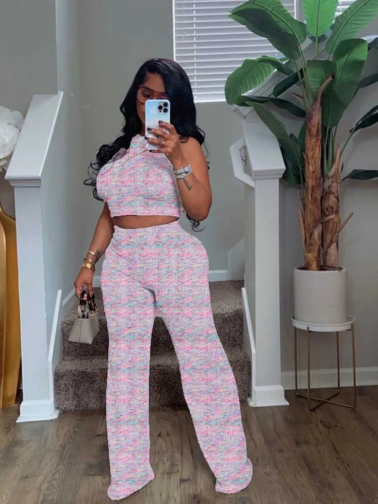 Woman taking a mirror selfie wearing a pink and white patterned outfit in a home setting.