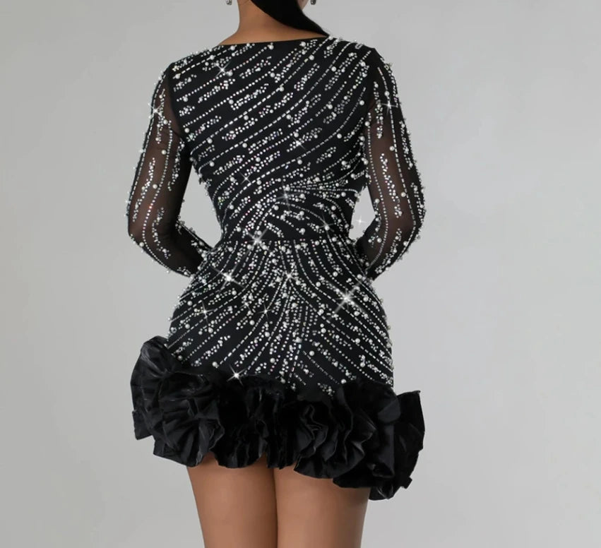 Black dress with sequin detailing on a gray background