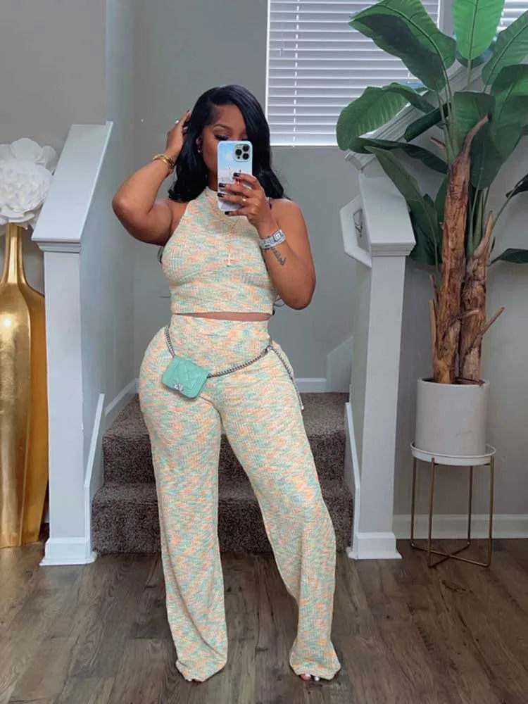 Woman taking a mirror selfie wearing a patterned outfit in a home setting.