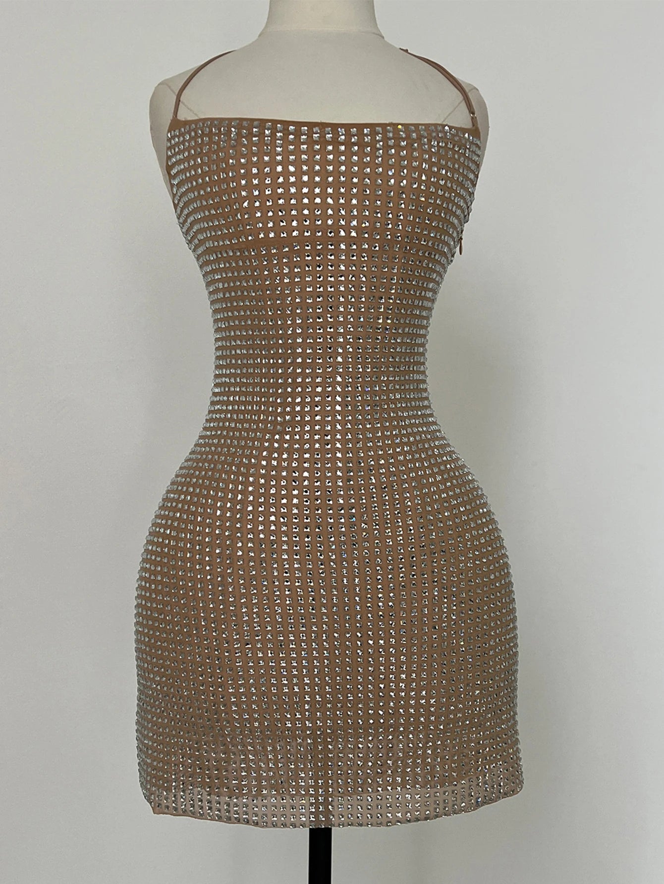 Dress made of small metallic studs on a mannequin against a plain background
