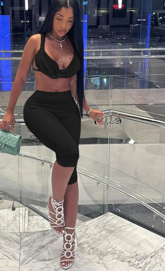 Woman in black outfit with green handbag in modern indoor setting