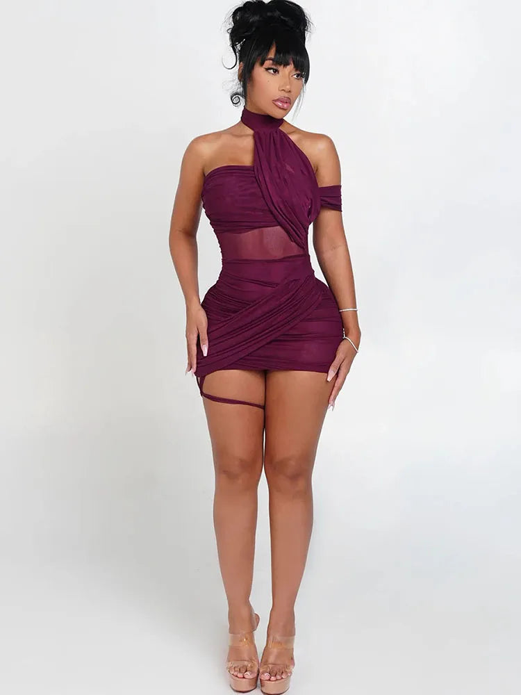 Woman wearing a burgundy dress with sheer panels on a white background
