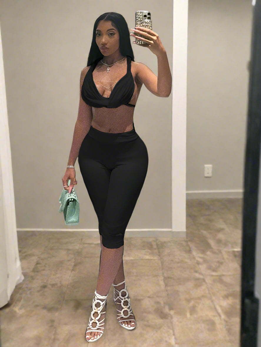 Person taking a mirror selfie in a bathroom wearing black athletic wear.