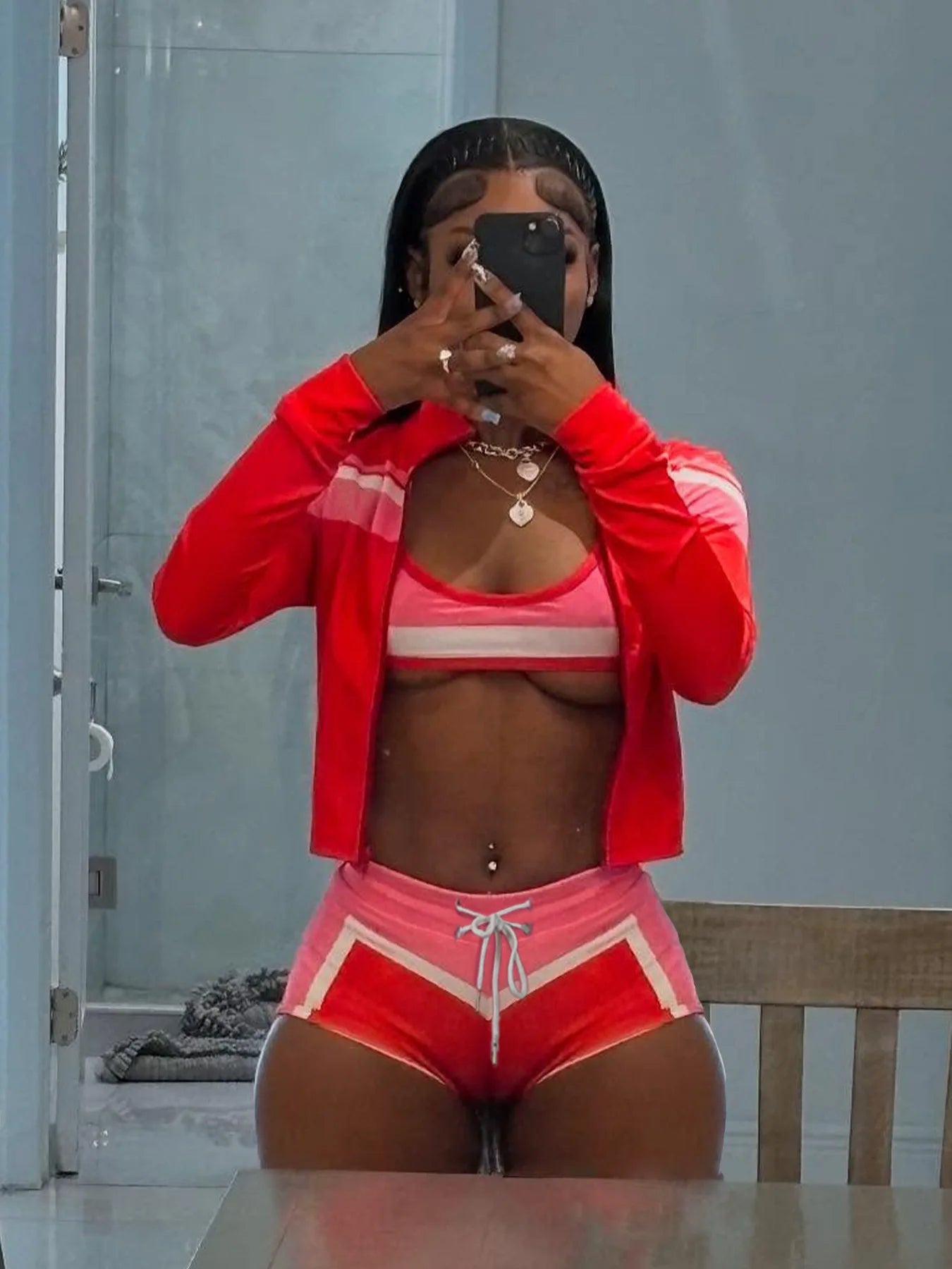 Person wearing a red athletic outfit taking a mirror selfie.