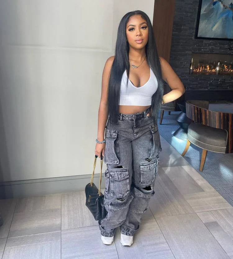 Woman in a stylish outfit with gray cargo pants and white top in an indoor setting.