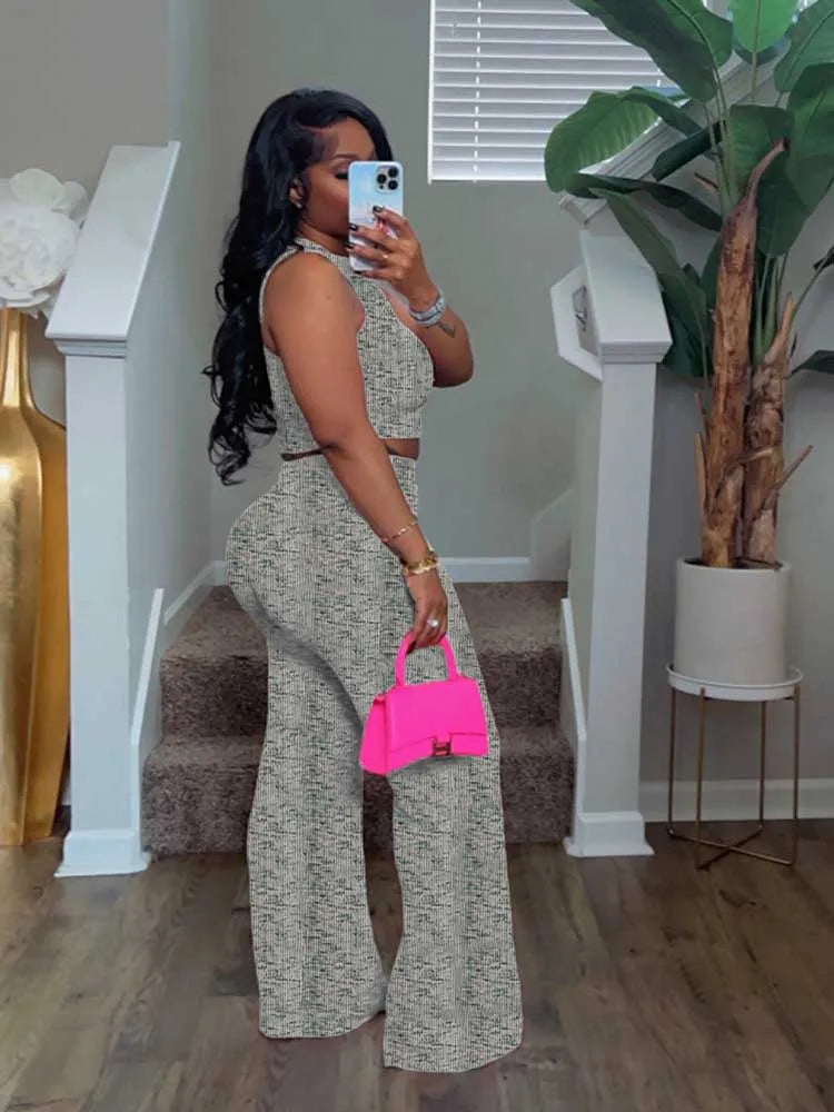 Woman taking a mirror selfie in a room with a plant and staircase.