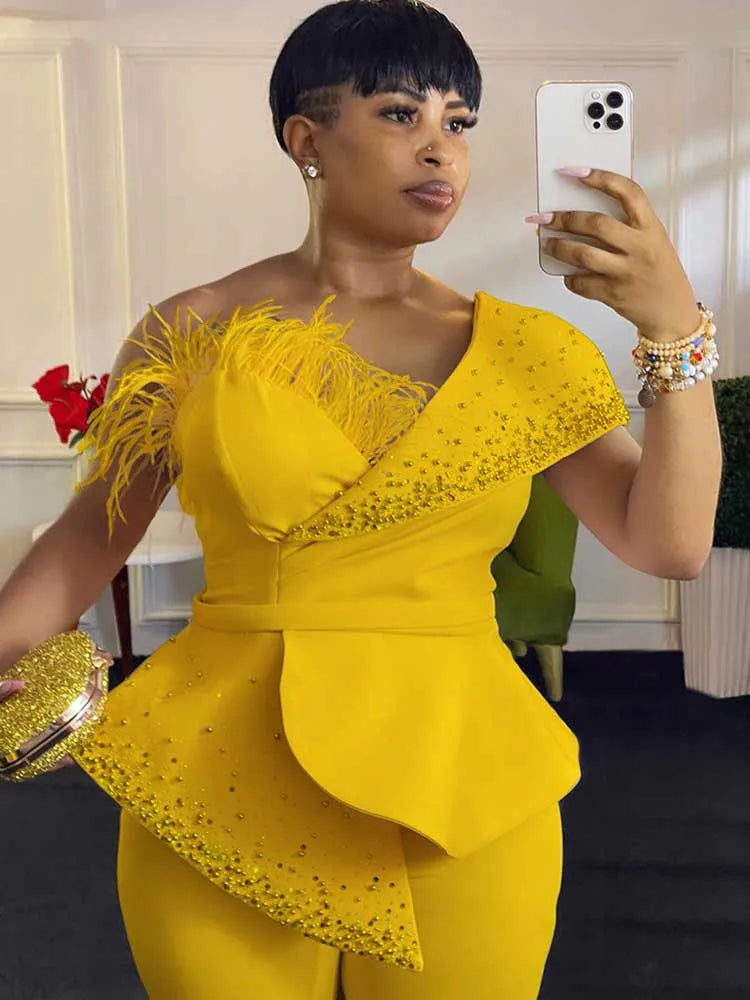 Woman in a yellow outfit with feather details taking a mirror selfie.