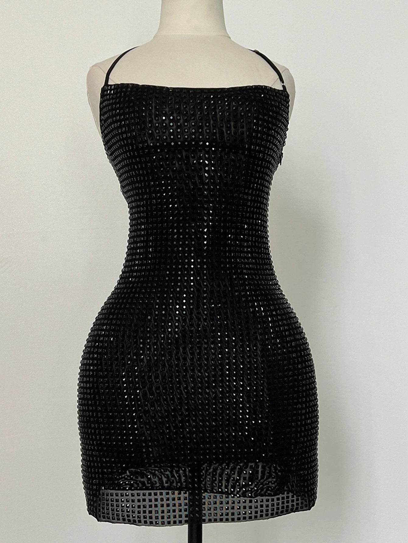 Black sequin dress on a mannequin against a white background