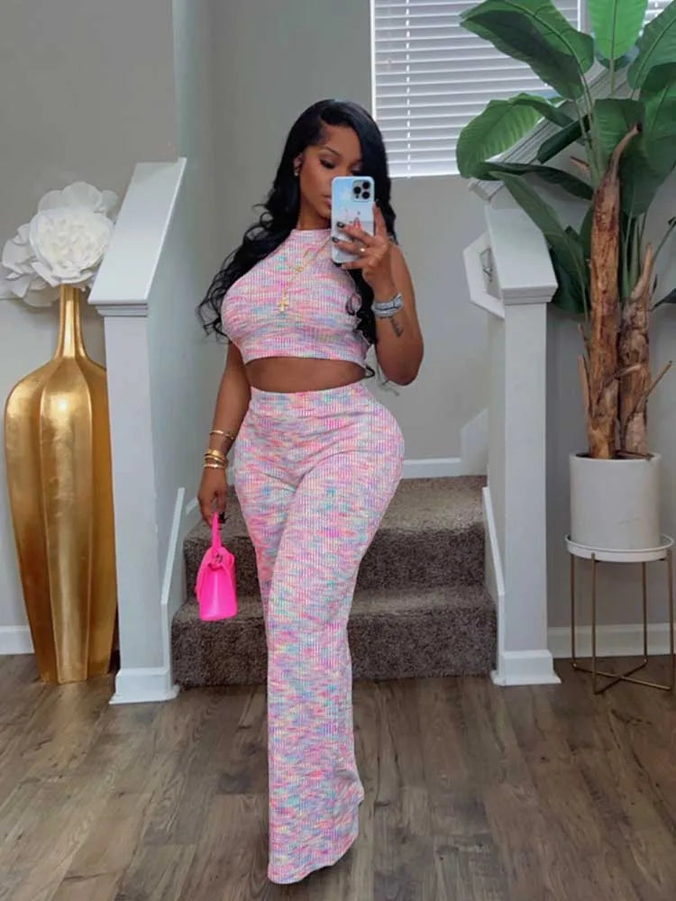 Woman in a patterned outfit taking a mirror selfie in a home setting.