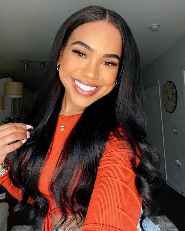 A woman with Silk Society straight tape-in extensions to her shoulders, wearing a red top.